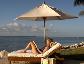 donna legge al mare sotto l'ombrellone