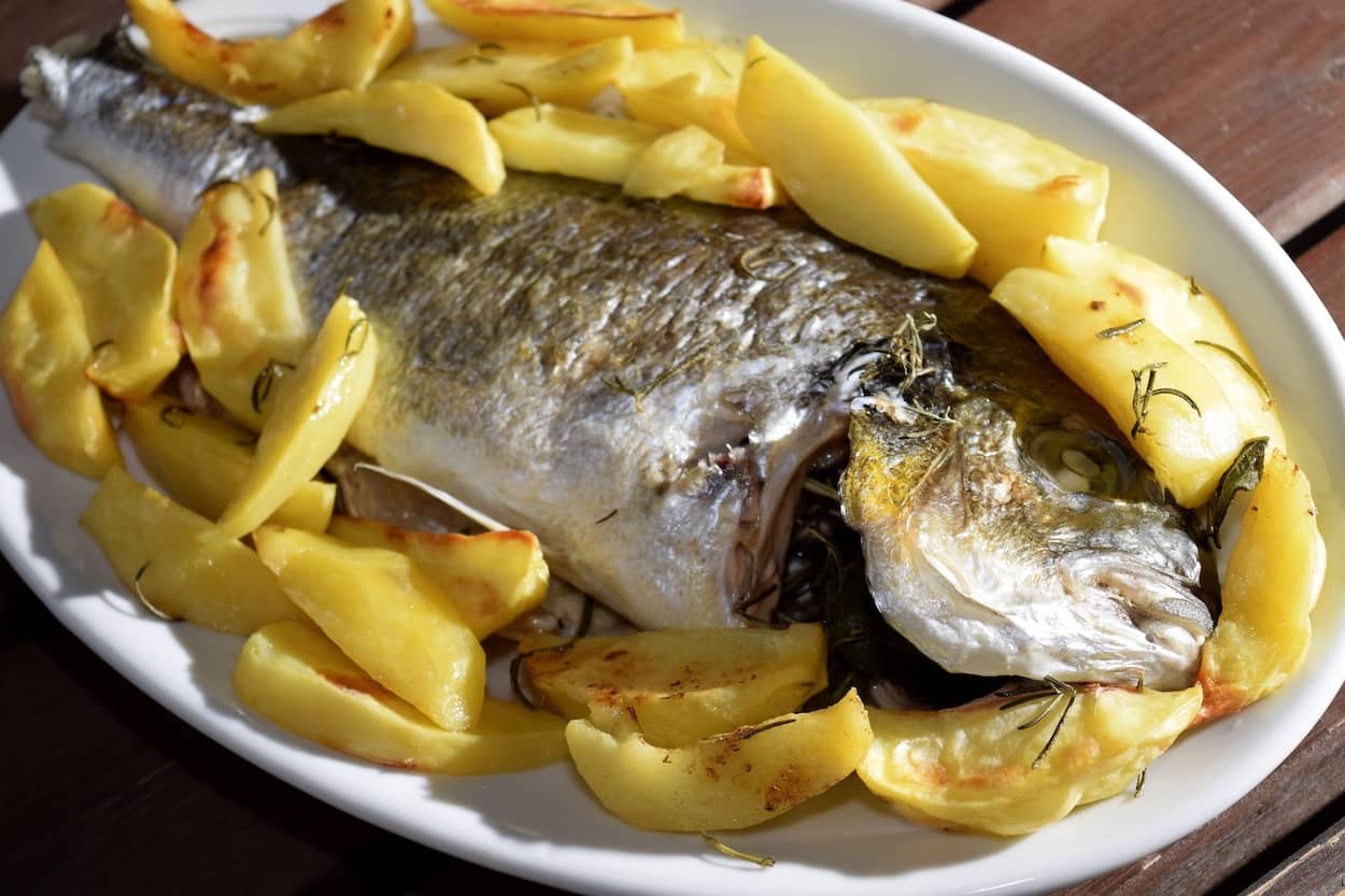 orata al forno con patate in teglia bianca