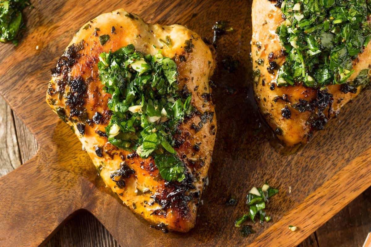 petti di pollo con grigliati con salsa chimichurri serviti su tagliere