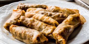 Involtini di cavolo turchi con riso e spezie serviti su piatto bianco – Lahana Sarması