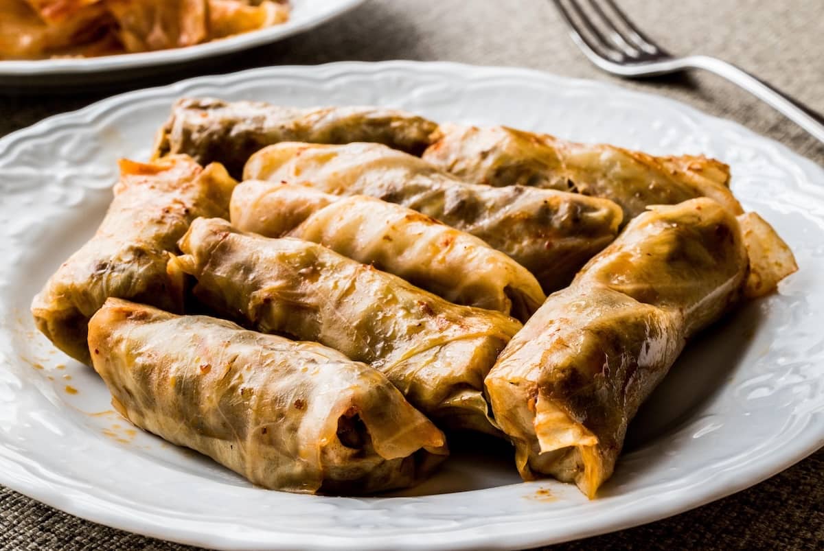 Involtini di cavolo turchi con riso e spezie serviti su piatto bianco – Lahana Sarması