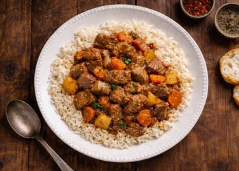 Tas kebabı: stufato turco di manzo con patate e carote servito su riso pilaf, foto dall’alto