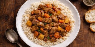 Tas kebabı: stufato turco di manzo con patate e carote servito su riso pilaf, foto dall’alto