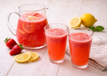 Limonata alla fragola fatta in casa con fragole fresche limone e caraffa di vetro