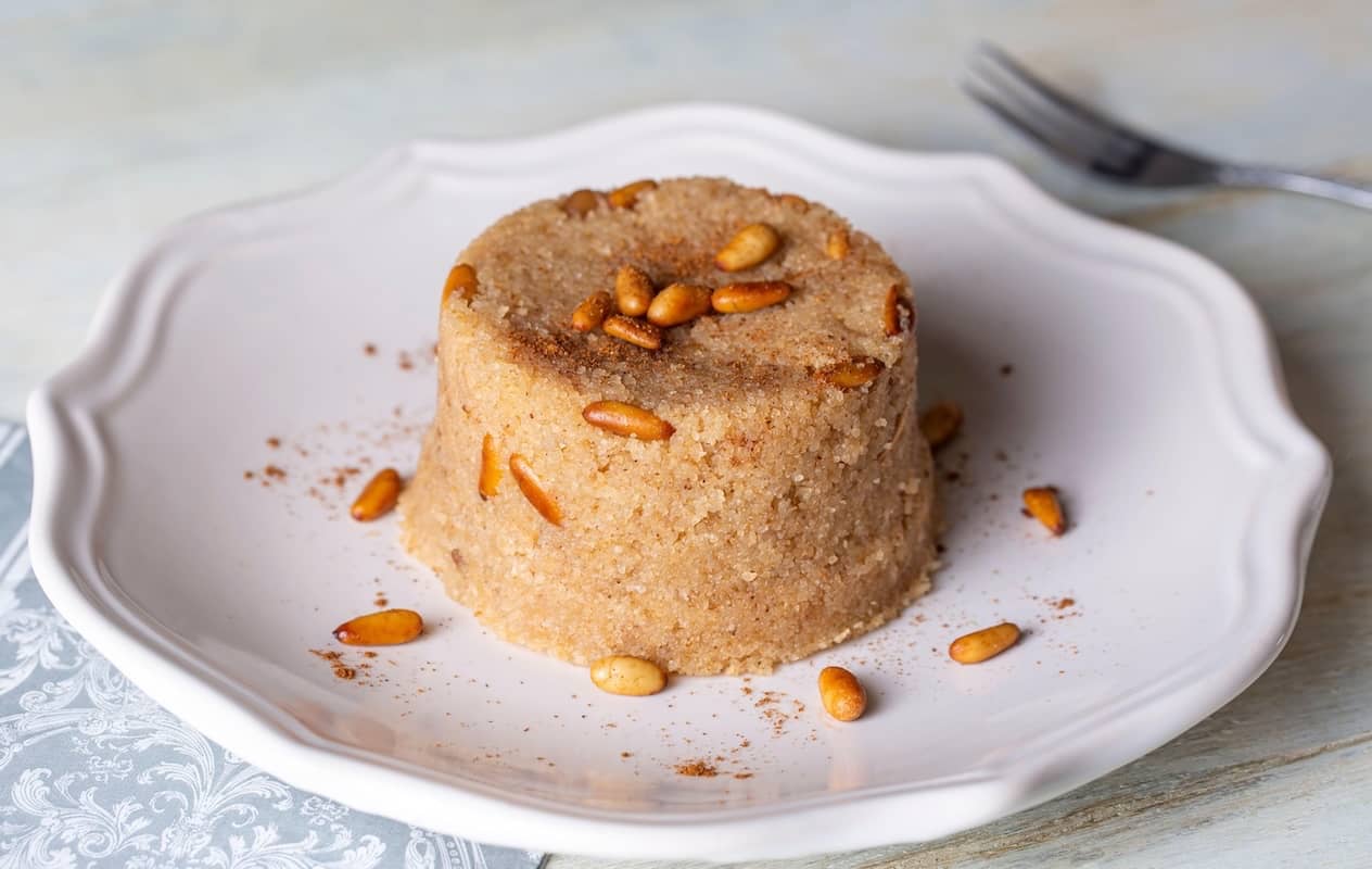 halva di semolino turca con pinoli servita in un piatto